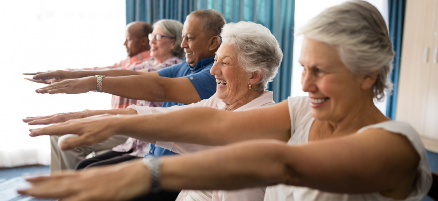 Seniors doing exercises at an assisted living home.